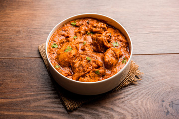 Murgh Makhani / Butter chicken tikka masala served with roti / Paratha and plain rice along with onion salad. selective focus
