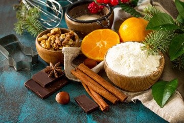 Christmas Baking background. Ingredients for Christmas baking - chocolate, cinnamon, flour, sugar, nuts, chocolate, spices on a stone or slate background. Seasonal food. Copy space.