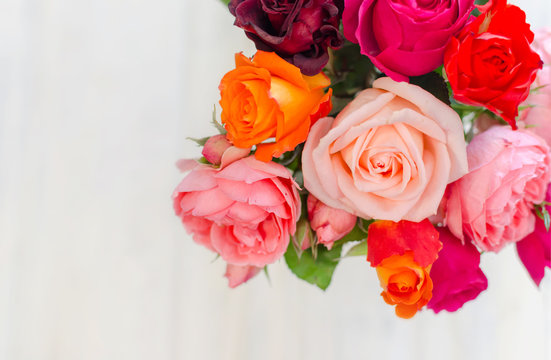 Valentines day background with colorful fresh roses laying on white table.