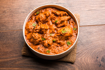 Murgh Makhani / Butter chicken tikka masala served with roti / Paratha and plain rice along with onion salad. selective focus
