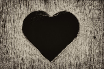 Fototapeta na wymiar Black heart in a wooden board. Love background.