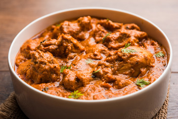 Murgh Makhani / Butter chicken tikka masala served with roti / Paratha and plain rice along with onion salad. selective focus