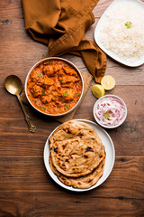 Murgh Makhani / Butter chicken tikka masala served with roti / Paratha and plain rice along with onion salad. selective focus