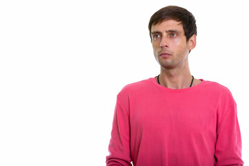 Fototapeta premium Studio shot of young handsome man thinking while looking up 