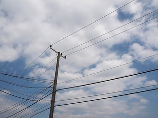 electrical wires on electric poles on blue sky background