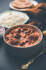 Murgh Makhani / Butter chicken tikka masala served with roti / Paratha and plain rice along with onion salad. selective focus