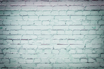 Brick wall painted with light green paint. Background with brickwork texture.