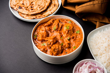 Murgh Makhani / Butter chicken tikka masala served with roti / Paratha and plain rice along with onion salad. selective focus