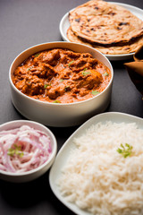 Murgh Makhani / Butter chicken tikka masala served with roti / Paratha and plain rice along with onion salad. selective focus