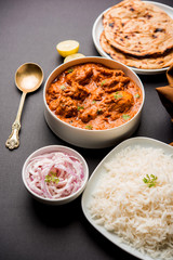 Murgh Makhani / Butter chicken tikka masala served with roti / Paratha and plain rice along with onion salad. selective focus