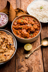Murgh Makhani / Butter chicken tikka masala served with roti / Paratha and plain rice along with onion salad. selective focus
