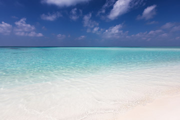 Fototapeta na wymiar Tropischer Traumstrand mit türkisem Wasser und feinem Sand unter tiefblauem Himmel