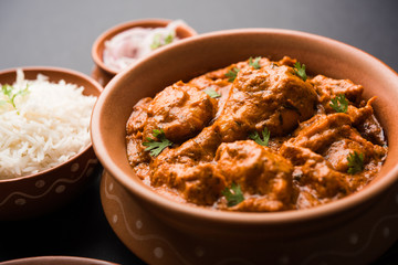 Murgh Makhani / Butter chicken tikka masala served with roti / Paratha and plain rice along with onion salad. selective focus