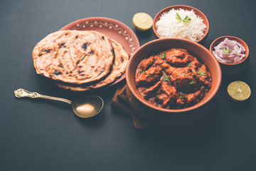 Murgh Makhani / Butter chicken tikka masala served with roti / Paratha and plain rice along with onion salad. selective focus