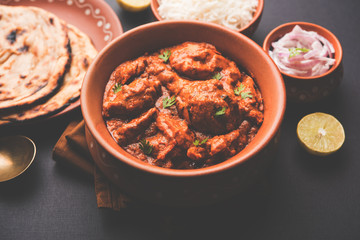 Murgh Makhani / Butter chicken tikka masala served with roti / Paratha and plain rice along with onion salad. selective focus