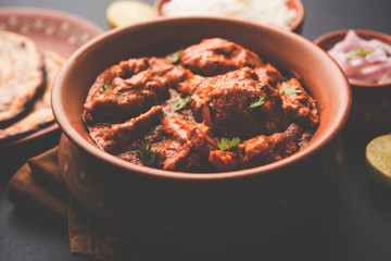 Murgh Makhani / Butter chicken tikka masala served with roti / Paratha and plain rice along with onion salad. selective focus
