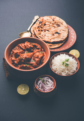 Murgh Makhani / Butter chicken tikka masala served with roti / Paratha and plain rice along with onion salad. selective focus