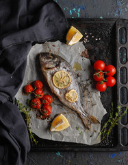Freshly made dorado fish stuffed with herbs and dor blue cheese, cherry tomatoes and lemon on a...