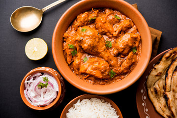 Murgh Makhani / Butter chicken tikka masala served with roti / Paratha and plain rice along with onion salad. selective focus