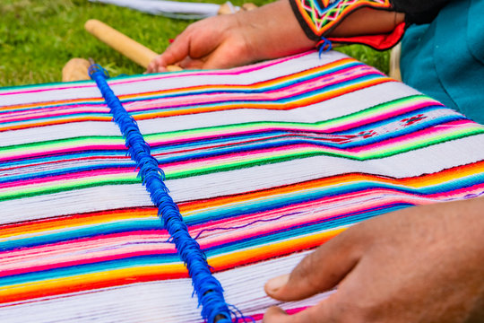 Peruanische Frau beim weben eines Wandteppich aus Alpakawolle
