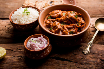 Murgh Makhani / Butter chicken tikka masala served with roti / Paratha and plain rice along with onion salad. selective focus