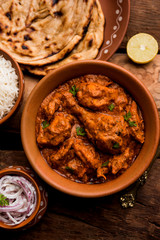 Murgh Makhani / Butter chicken tikka masala served with roti / Paratha and plain rice along with onion salad. selective focus