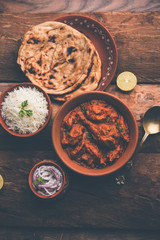 Fototapeta na wymiar Murgh Makhani / Butter chicken tikka masala served with roti / Paratha and plain rice along with onion salad. selective focus