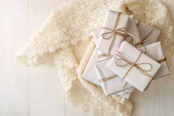 Beige boxes with gifts on a light wooden background