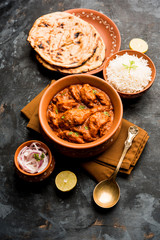 Murgh Makhani / Butter chicken tikka masala served with roti / Paratha and plain rice along with onion salad. selective focus