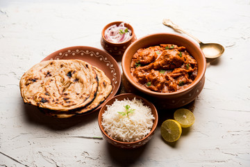 Murgh Makhani / Butter chicken tikka masala served with roti / Paratha and plain rice along with onion salad. selective focus