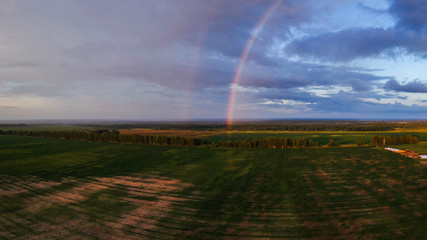 Naklejka na ściany i meble View of the rainbow over the field from a height