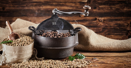 Old vintage cast iron coffee roaster and raw beans