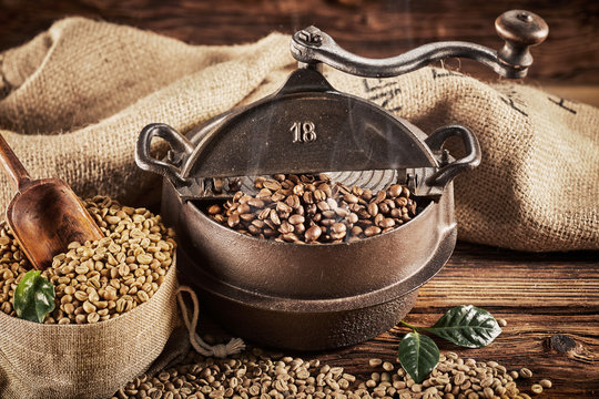 Ancient old cast iron coffee roaster with beans