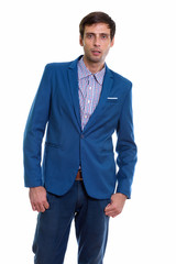 Studio shot of young handsome businessman standing