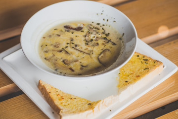 mushroom cream soup with mushrooms, herb and garlic toast on the side