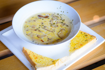mushroom cream soup with mushrooms, herb and garlic toast on the side
