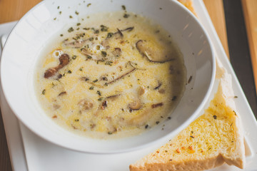 mushroom cream soup with mushrooms, herb and garlic toast on the side