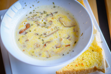 mushroom cream soup with mushrooms, herb and garlic toast on the side