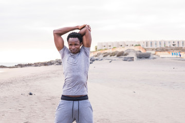 black race african athlete do stretching outdoor at the beach after a train session alone. health care and healthy lifestyle for diversity people. Attractive afro man with muscles