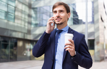 Businessman talking about work on the mobile phone at the street