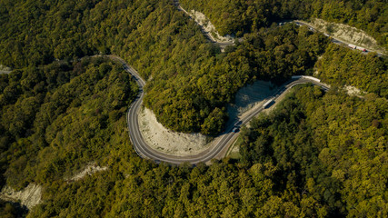 Directly above view of cars on a curvy road. Aerial drone shoot in the mountains.