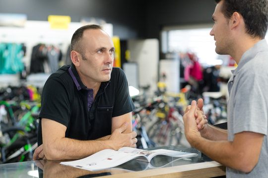 men discussing in bicycle store