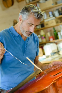 Closeup of craftsman making musical instrument bridge