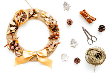 Christmas decoration concept. Creative christmas wreath made of thread near matherials and instruments, sciccors on white background top view