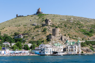 Pier and beach in the sea bay. Russia, Republic of Crimea, Balaclava. 11.06.2018: View of the coast...