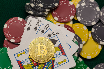 Casino chips, bitcoin and poker cards on green table