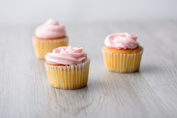 Tasty cupcake on wooden background. Birthday cupcakes on gray wooden background. Space for Text. Three cupcake.