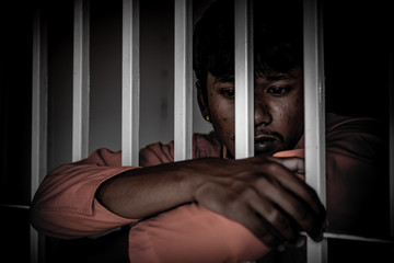 Asian Men desperate to catch the iron prison,prisoner concept,thailand people,Hope to be free.