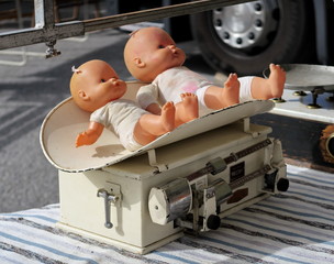 poupées sur un pèse bébé ancien