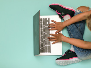 Girl with a laptop on the blue floor. The view from the top.
